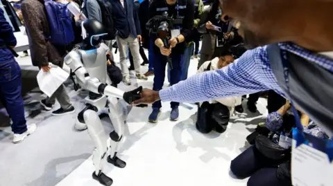 Getty Images Unitree's G1 robot shakes the hand of an attendee at the Mobile World Congress 2025 in Barcelona, Spain, on 5 March, 2025.