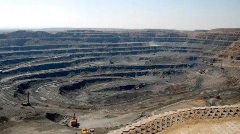 Getty Images Trucks work in a vast rare-earth mine in Inner Mongolia, China.